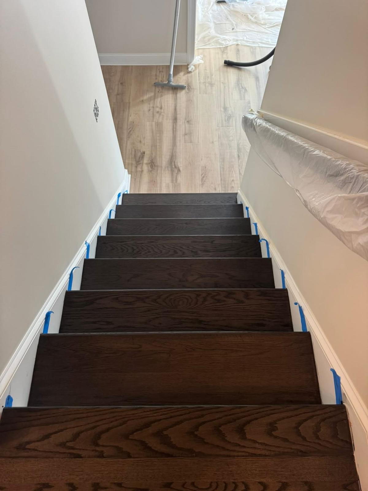 Espresso-stained hardwood staircase with light LVP landing