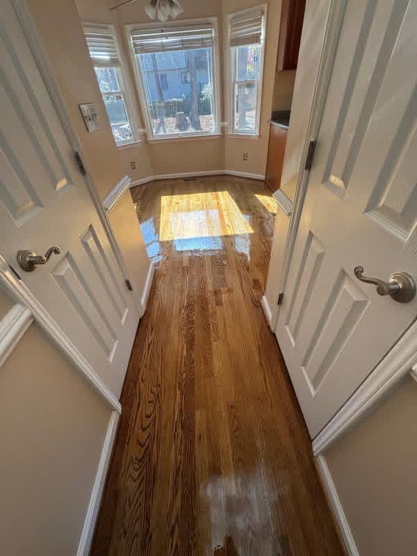 Refinished oak flooring in a bright bay-window nook